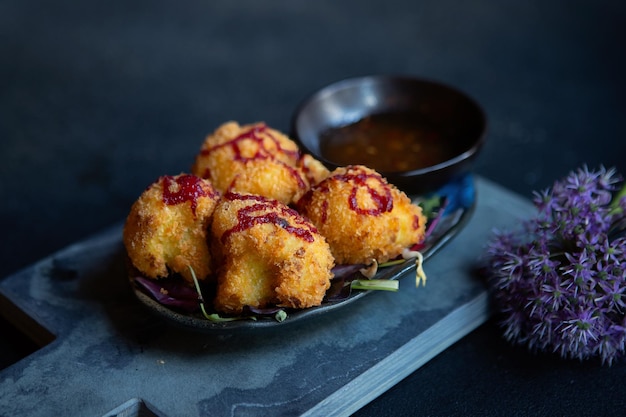 Légumes frits asiatiques avec sauce sur fond sombre gros plan