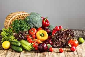 Photo gratuite les légumes d'un panier sur une table en bois