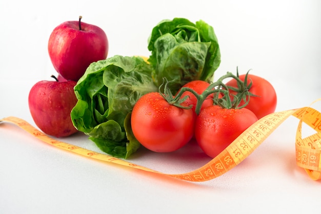 Photo gratuite légumes avec ruban à mesurer sur la table