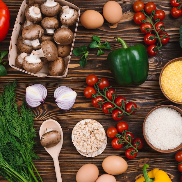 Légumes sains; des œufs; gâteau de riz soufflé et polenta sur un bureau en bois