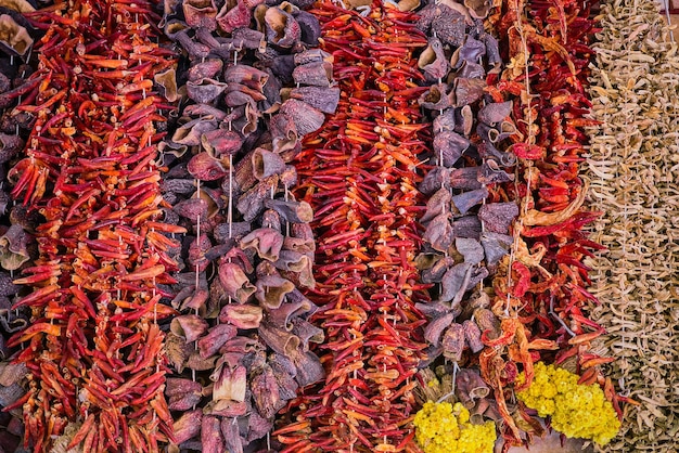 Photo gratuite légumes secs dans un bazar traditionnel en turquie sur la côte égéenne aubergines crues sèches au poivron rouge et okra pendent devant le banc