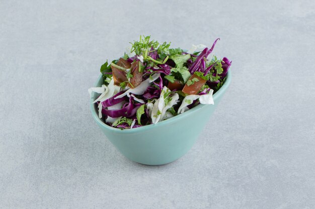 Légumes tranchés délicieux dans un bol, sur fond de marbre.