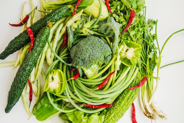Photo gratuite légumes verts au piment rouge sur fond blanc