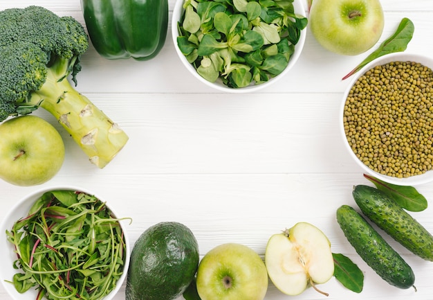 Photo gratuite légumes verts disposés en forme circulaire sur un tableau blanc