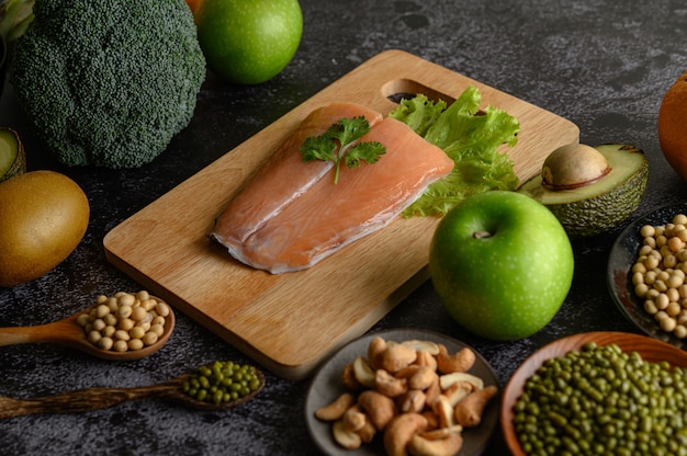 Légumineuses, Fruits Et Morceaux De Poisson Saumon Sur Une Planche à Découper En Bois.