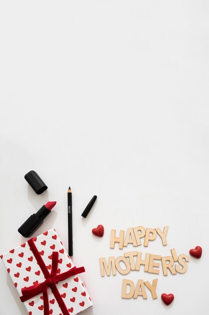 Lettre heureux de la fête des mères au rouge à lèvres, eye-liner et boîte cadeau