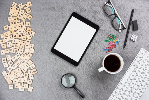 Lettres en bois; tablette numérique; tasse à café et fournitures de bureau sur fond gris