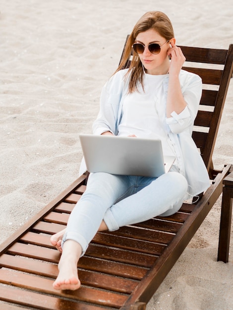 Élevé, angle, femme, plage, chaise, fonctionnement, ordinateur portable