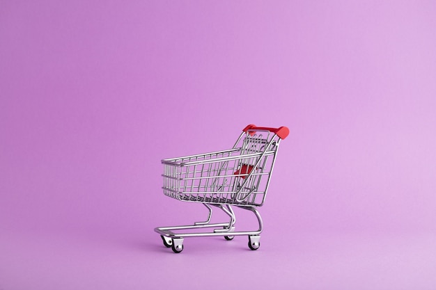 Libre d'un chariot vide prêt pour les achats de Noël, fond violet