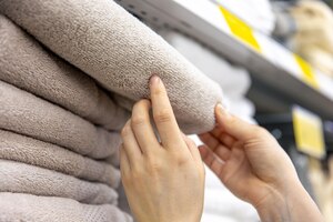 Photo gratuite libre une femme choisit une serviette dans un magasin d'articles ménagers