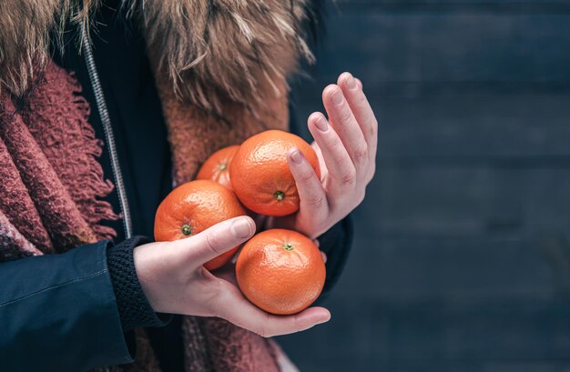 Libre de mandarines dans les mains des femmes sur un arrière-plan flou