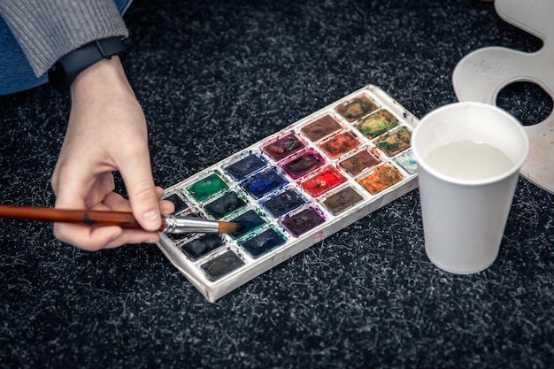 Photo gratuite libre d'une palette de peintures et un verre d'eau