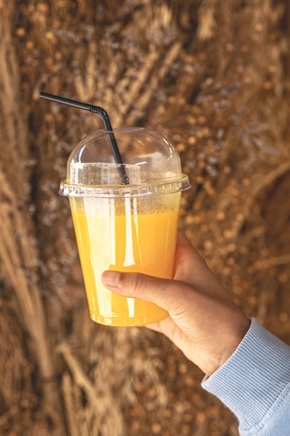 Libre un verre de jus d'orange dans une main féminine