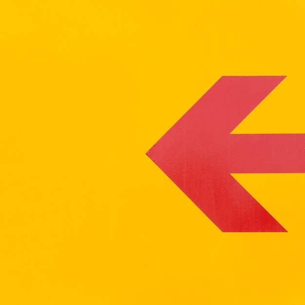 Photo gratuite ligne de flèche rouge minimaliste sur fond jaune