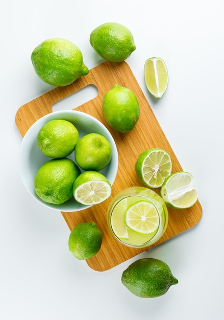 Limonade aux citrons dans un verre blanc et planche à découper, vue du dessus.