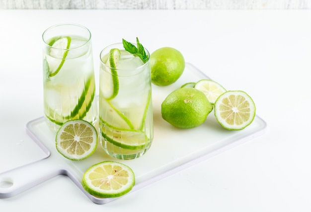Limonade dans des verres au citron, basilic, planche à découper high angle view on white and grungy