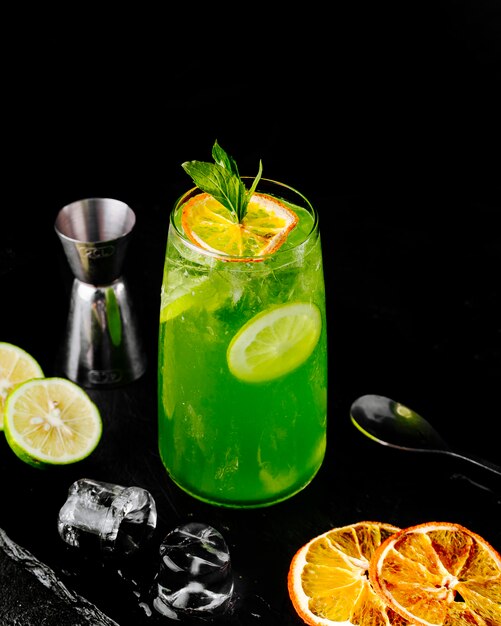 Limonade verte fraîche avec du jus de citron orange et des tranches à la menthe.