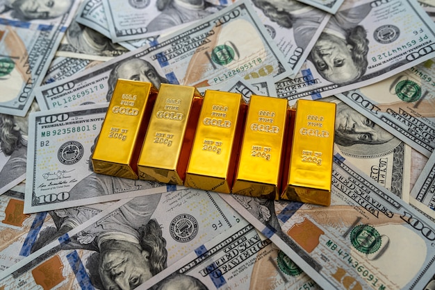 Lingots d'or sur pile de billets d'un dollar américain comme arrière-plan. concept de finance et d & # 39; épargne