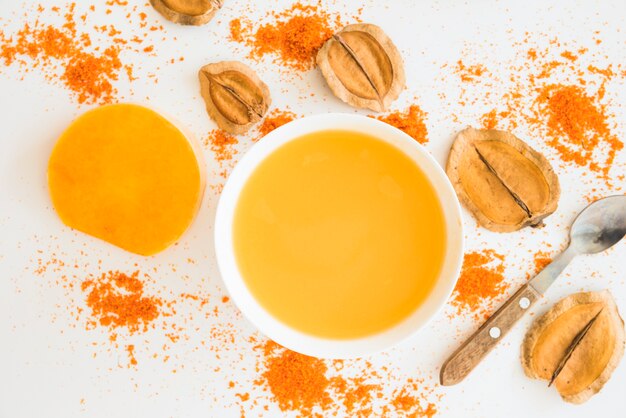 Liquide orange entre feuillage et poivre
