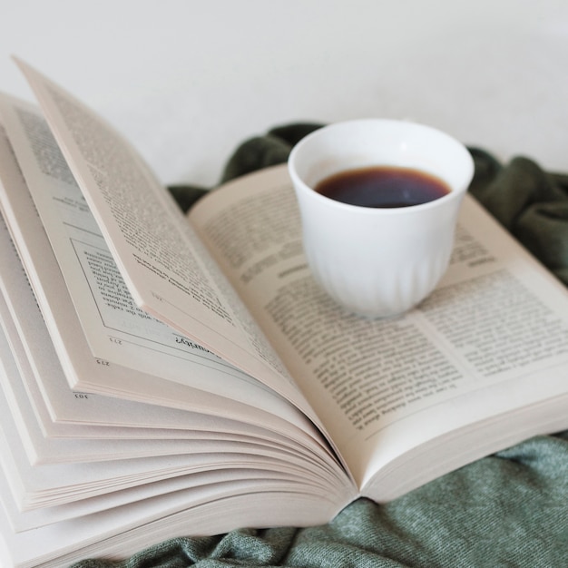 Photo gratuite lire un livre et boire du café