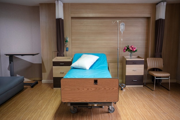 Lit patient réglable vide avec une solution saline dans une chambre privée à l'hôpital