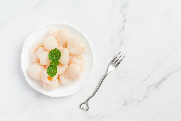 Litchi au sirop sur surface blanche