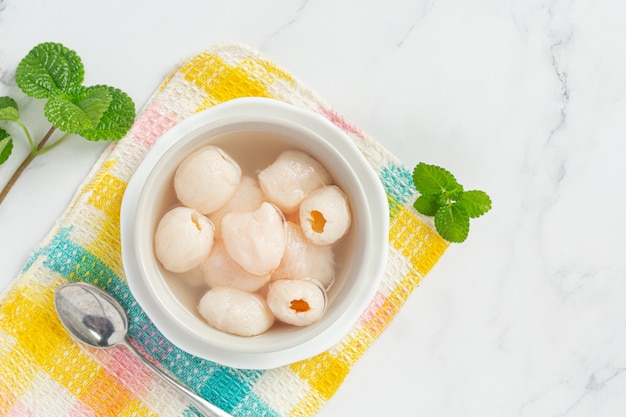 Litchi au sirop sur surface blanche