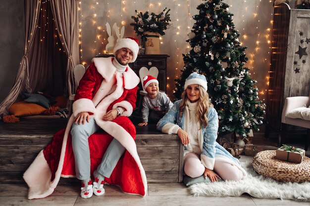 Little Santa, Father Frost et Snow Maiden souriant à l'intérieur de Noël avec arbre de Noël décoré.