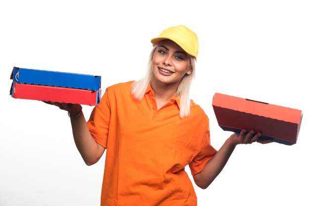 Livraison de pizza femme tenant une pizza sur fond blanc en souriant. Photo de haute qualité