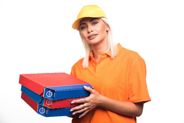 Photo gratuite livraison de pizza femme tenant une pizza sur fond blanc tout en regardant. photo de haute qualité