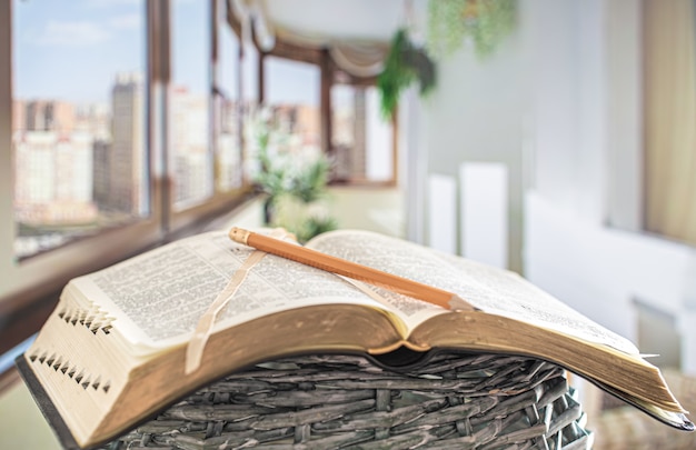 Livre Bible avec gros plan au crayon, sur une belle terrasse.