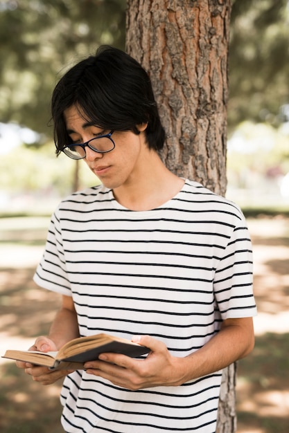 Photo gratuite livre de lecture d'un adolescent asiatique