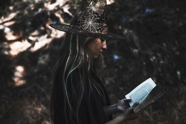 Livre de lecture de Dame en costume de sorcière