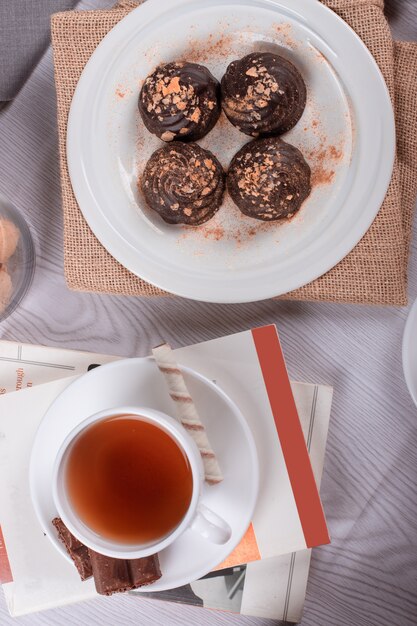 Livre, tasse de thé et chocolat sur la table