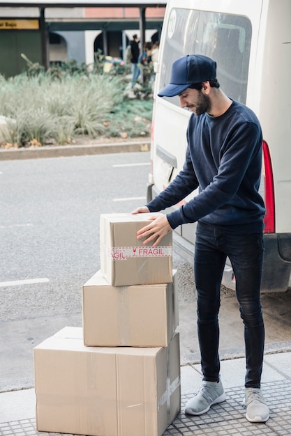 Livrer un homme en regardant des boîtes en carton empilées