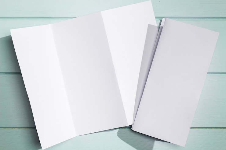 Photo gratuit livret pliable en papier blanc posé