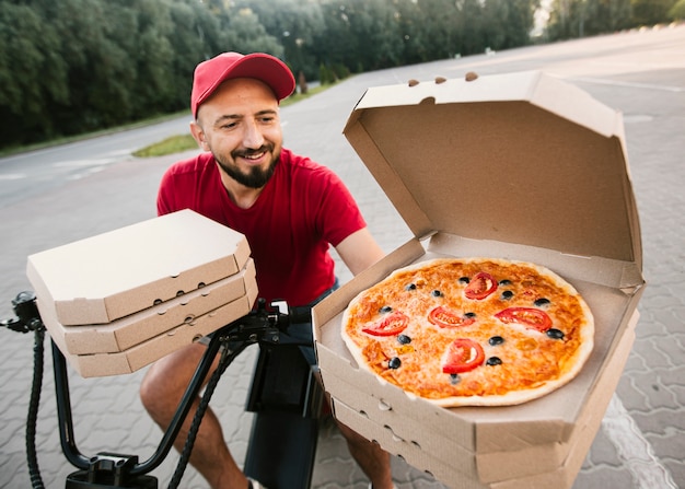 Livreur à angle élevé avec boîte à pizza ouverte