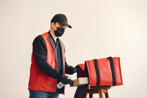 Photo gratuite livreur aseptisant en aérosol sur une boîte