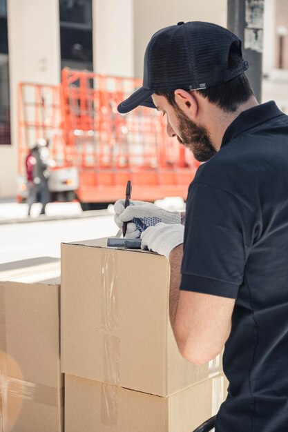 Livreur avec des boîtes en carton écrit sur le presse-papiers