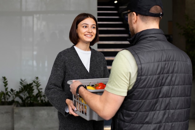 Photo gratuite livreur donnant la commande d'épicerie au client