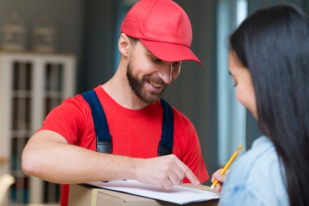 Livreur montrant la femme où signer pour recevoir la commande