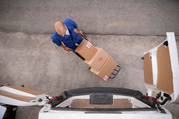 Livreur plein coup transportant des boîtes vue de dessus