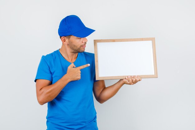 Livreur pointant le doigt au tableau blanc en t-shirt bleu