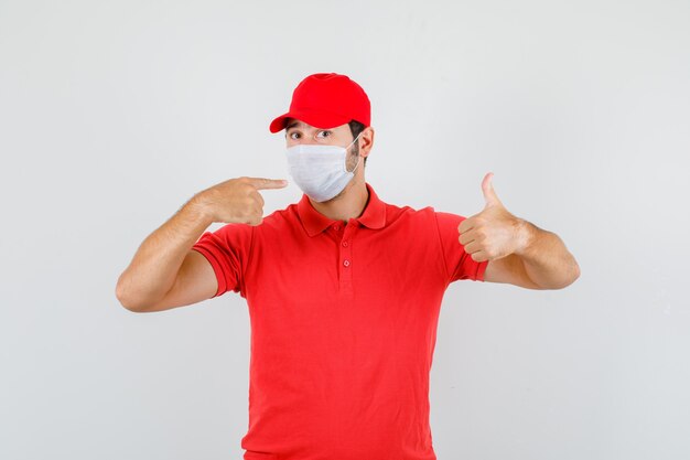Livreur pointant sur le masque avec le pouce vers le haut en t-shirt rouge