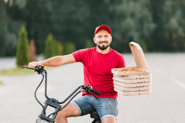 Photo gratuite livreur de smileys à tir moyen sur moto