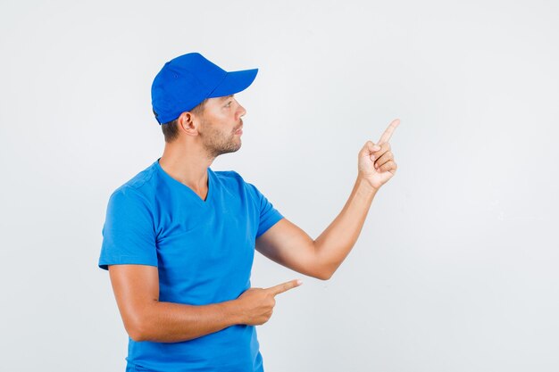 Livreur en t-shirt bleu, casquette montrant quelque chose avec les doigts