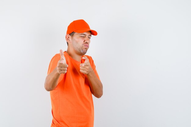 Livreur en t-shirt orange et casquette imitant le geste des armes à feu