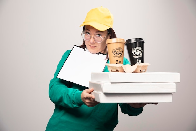 Livreur tenant un carton de tasses à café sur un blanc. photo de haute qualité