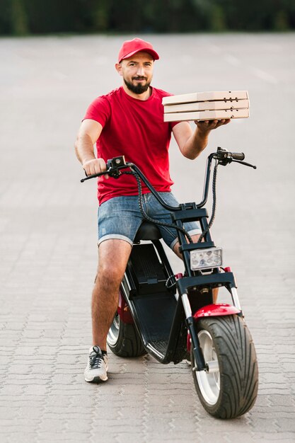 Livreur de tir complet tenant des boîtes à pizza