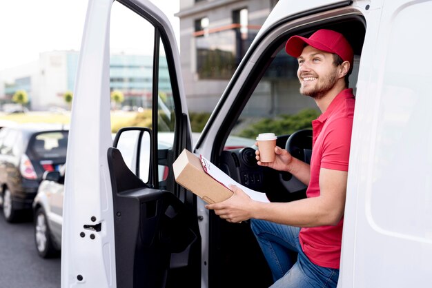 Livreur en voiture avec café